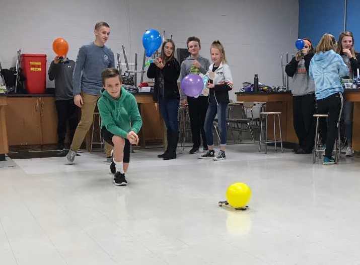 students sending a balloon car across a room